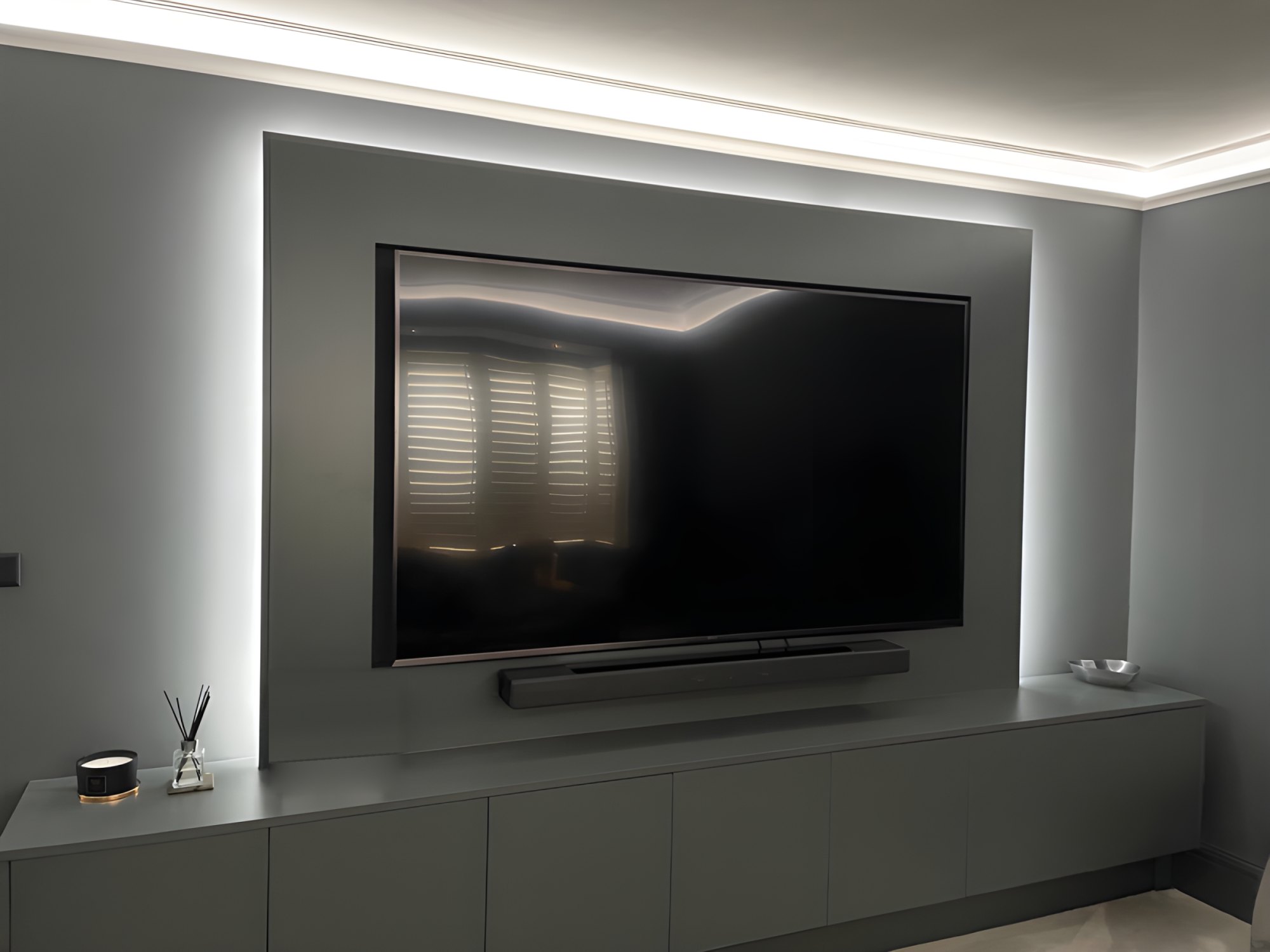 Dark grey media wall with backlit LED panel, wall-mounted TV and long low cabinet